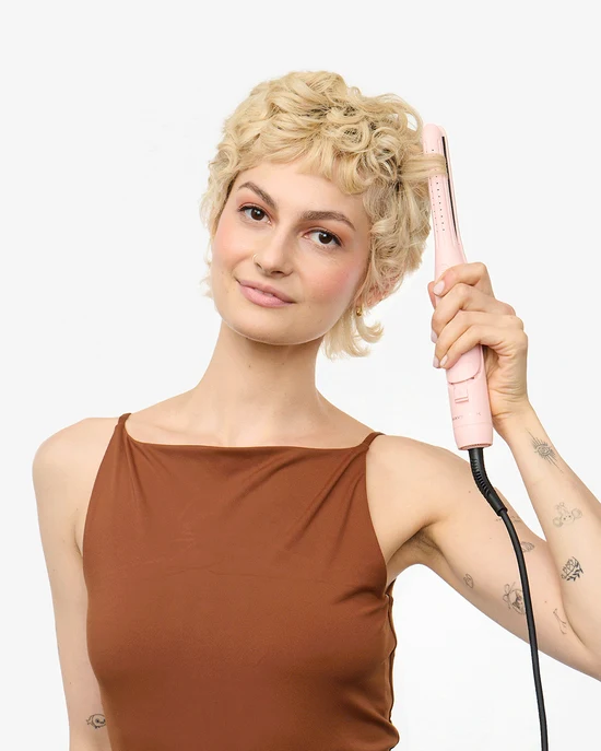 Model styling short curls with the pink Cool Curl Pencil